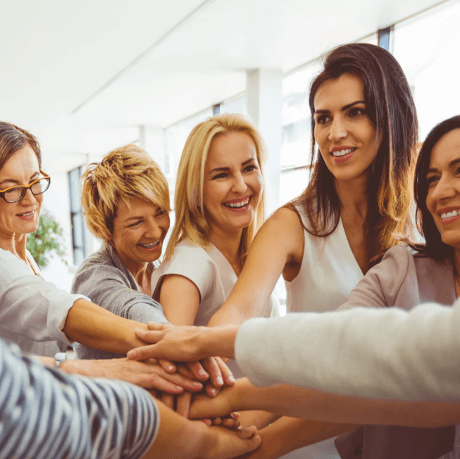 Grupo de mujeres uniendo sus manos como gesto de apoyo
