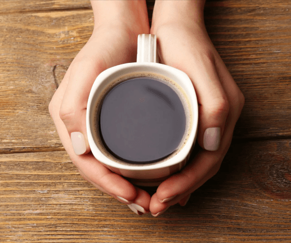 Manos sosteniendo una taza de café