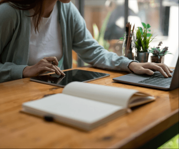 Persona trabajando con un ordenador y material de escritura