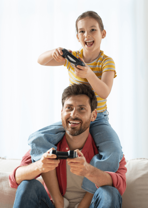 Padre y su hija compartiendo una partida con mandos de videojuegos