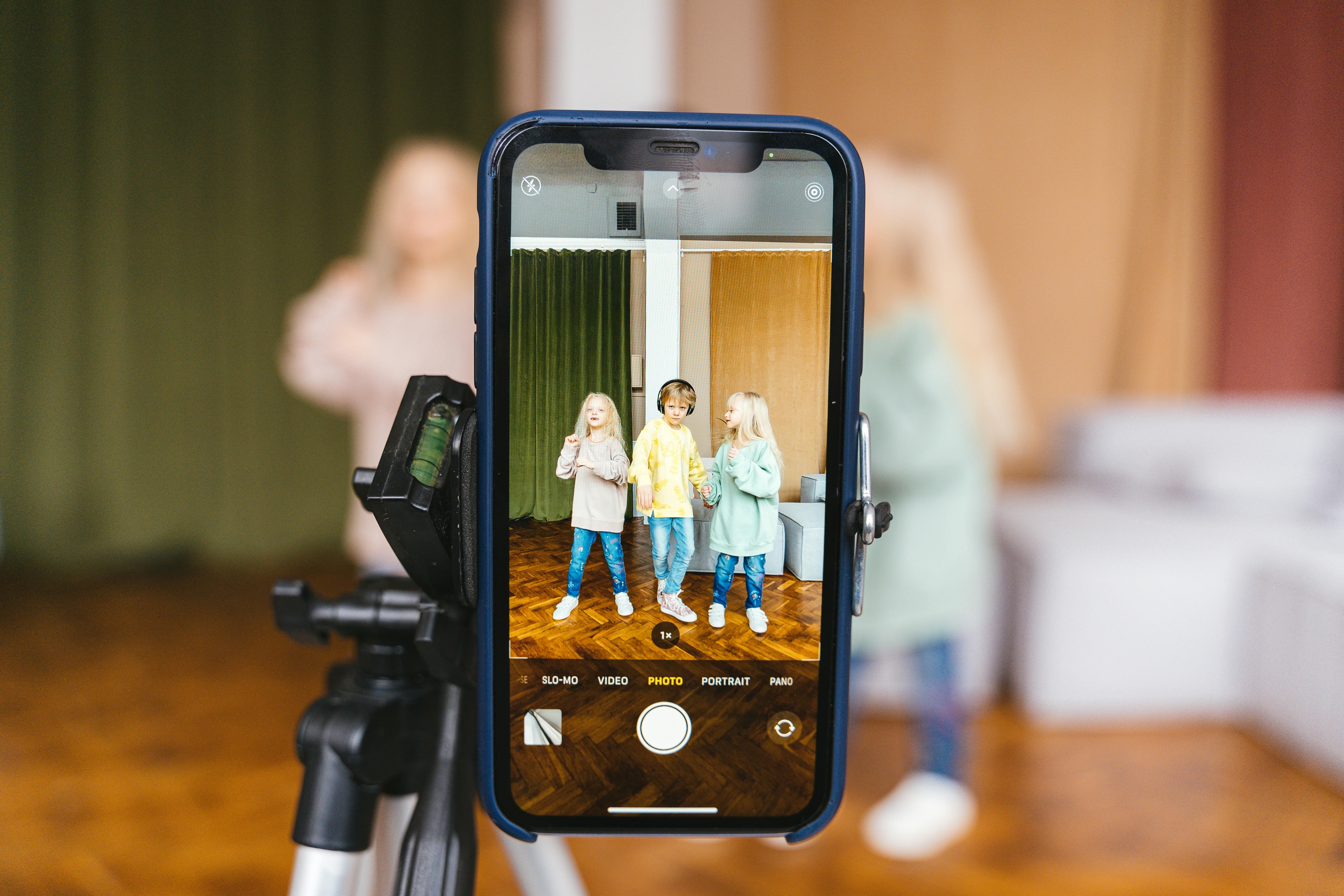 Teléfono grabando a un grupo de niños para publicar contenido en redes sociales