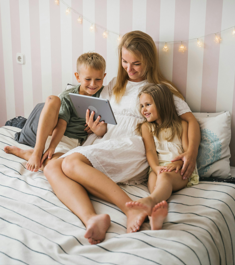Madre y sus dos hijos consultando juntos una tableta